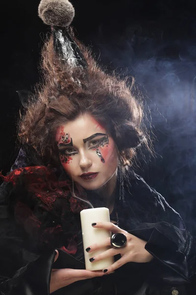 Mujer joven con disfraz de carnaval sosteniendo una vela . — Foto de Stock