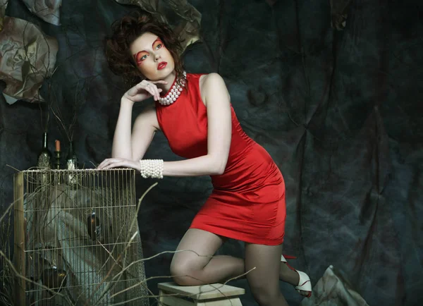 Молодая женщина с творческим обликом в красном платье — стоковое фото