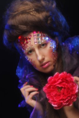 sanatsal visage büyük kırmızı çiçek tutan genç kadınla