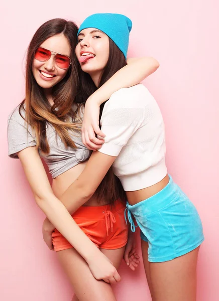 Feliz sorrindo meninas bonitas adolescentes ou amigos abraçando sobre rosa — Fotografia de Stock