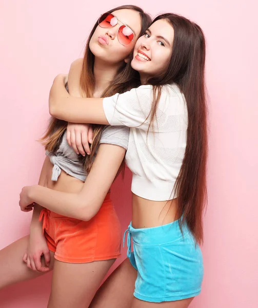 Feliz sonriente bonita adolescente niñas o amigos abrazándose sobre rosa —  Fotos de Stock