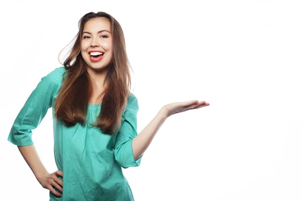 Jonge glimlachende vrouw wijst een hand met positieve gezichtsuitdrukking — Stockfoto