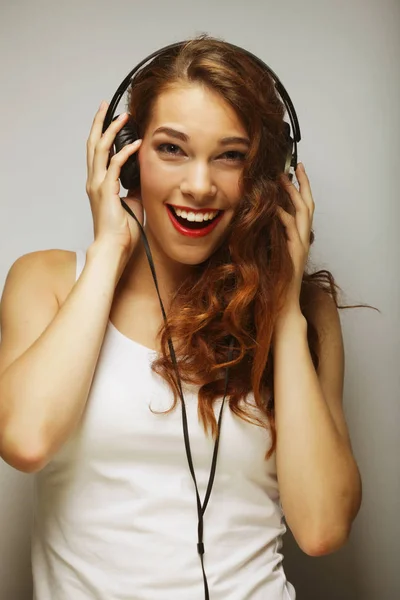 Mujer joven con auriculares escuchando música — Foto de Stock