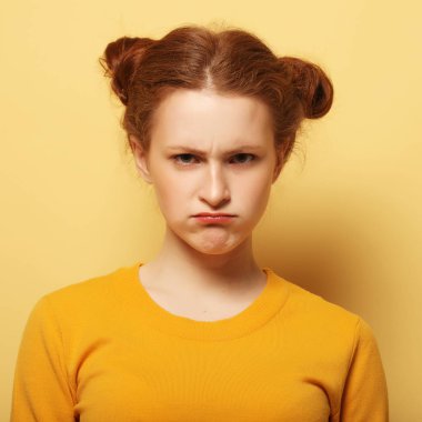 genç kadın sarı arka plan üzerinde düşünme çatık