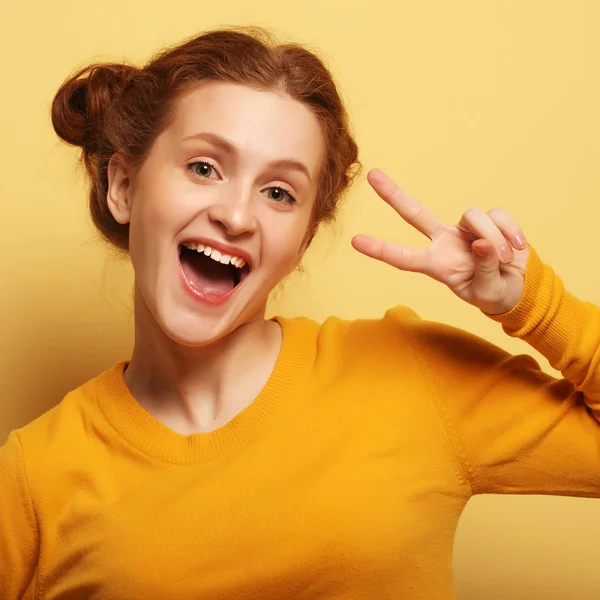 Krásná mladá překvapen redhair žena nad žlutým pozadím — Stock fotografie