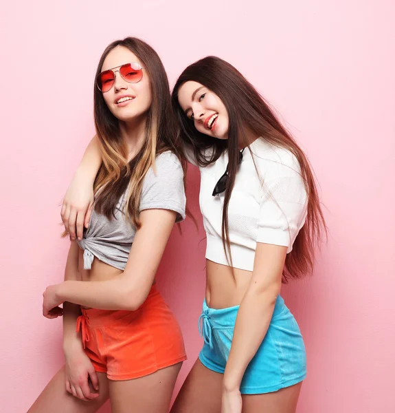 Feliz sonriente bonita adolescente niñas o amigos abrazándose sobre rosa —  Fotos de Stock