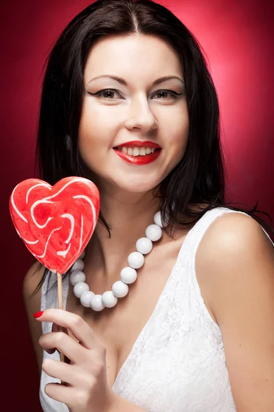 年轻漂亮的女人拿着棒棒糖的流行. — 图库照片