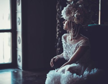 Güzel gelin bir sandalyeye oturur. Lüks Sarayı.