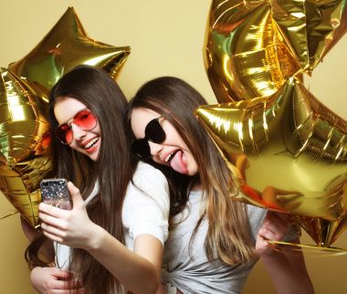 İki genç kız arkadaş altın Balonlu selfie üzerinde bir p yapmak