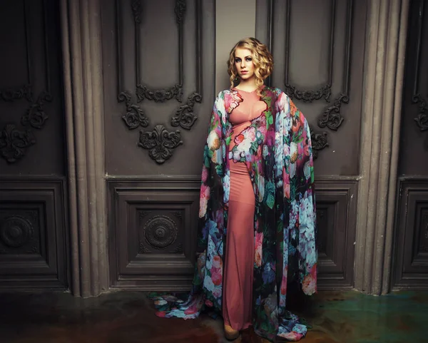 Красивая женщина в платье цветов стоит во дворце — стоковое фото