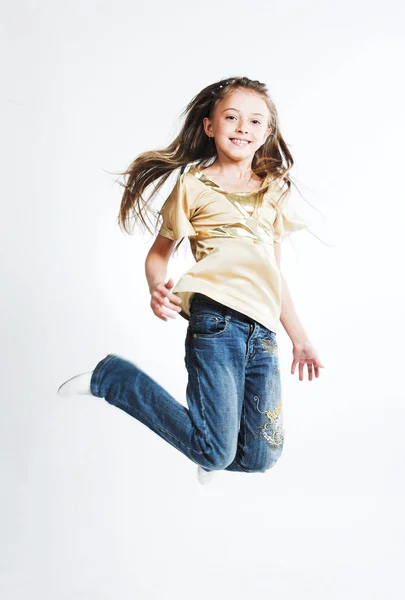 Kleines Mädchen springt über weißen Hintergrund — Stockfoto