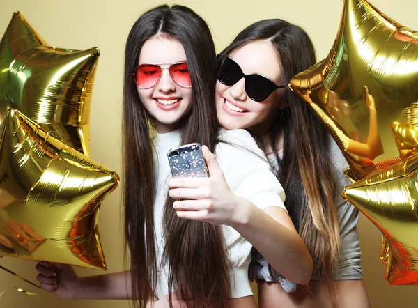 Two teenage girls friends with gold balloons  make selfie on a p — Stock Photo, Image