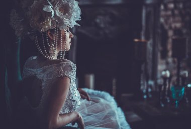 Güzel gelin bir sandalyeye oturur. Lüks Sarayı.