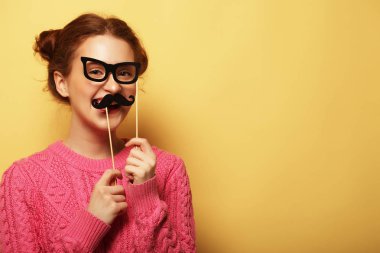 Sahte bıyık ve gözlük sarı backgro üzerinde olan kadın