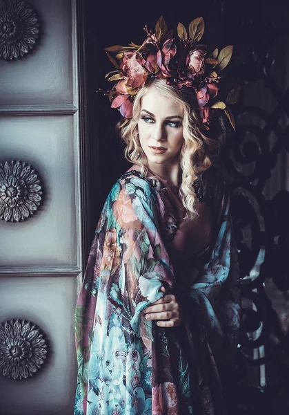 Bella donna in un abito di colori floreali con corona di fiori — Foto Stock