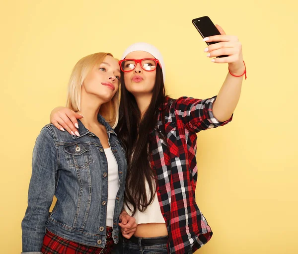 Gelukkig meisjes met smartphone op gele achtergrond. Gelukkig zelf — Stockfoto