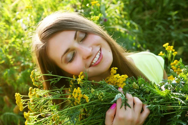 Jonge vrouw en wilde bloemen. — Stockfoto
