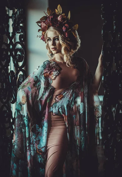 Piękna kobieta w sukience w kwiatowych kolorach stoi w pałacu — Zdjęcie stockowe