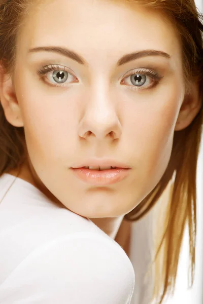 La cara de una hermosa mujer joven y sexy con la piel limpia en un blanco —  Fotos de Stock