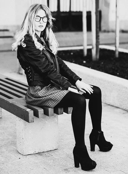 Blonde gir sits on a bench, summer city, black and white picture — Stock Photo, Image