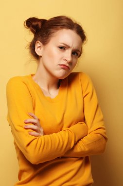 genç kadın sarı arka plan üzerinde düşünme çatık