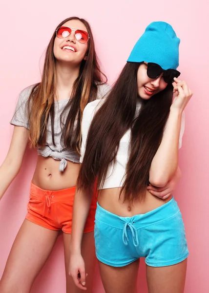 Feliz sorrindo meninas bonitas adolescentes ou amigos abraçando sobre rosa — Fotografia de Stock