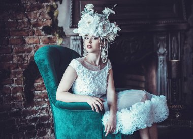 Güzel gelin bir sandalyeye oturur. Lüks Sarayı.