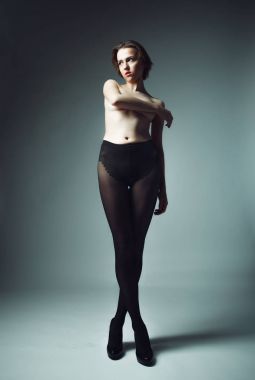 Siyah külotlu çorap giyen kısa sarı saçlı bir manken.