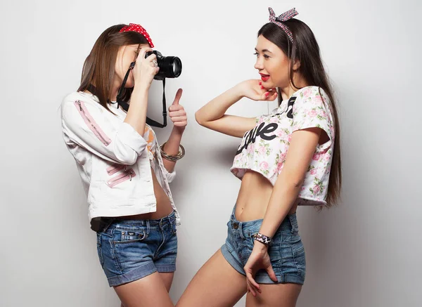 Felice ragazze amiche scattare alcune foto con macchina fotografica, su sfondo bianco — Foto Stock