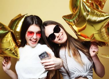İki genç kız arkadaş altın Balonlu selfie üzerinde bir p yapmak
