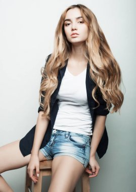 Genç, güzel kıvırcık kadın beyaz arka planda poz veriyor.