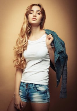 Genç güzel kıvırcık kadın sarı arka plan üzerinde poz