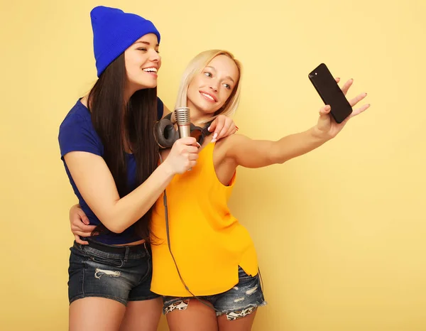 Meninas felizes com smartphone sobre fundo amarelo. Eu mesmo feliz — Fotografia de Stock