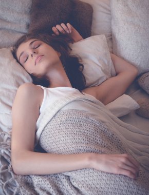 Genç kadın yatakta uyuyor.