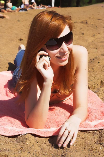 Young beautiful sexy red  womani laying on sea beach — Stock Photo, Image