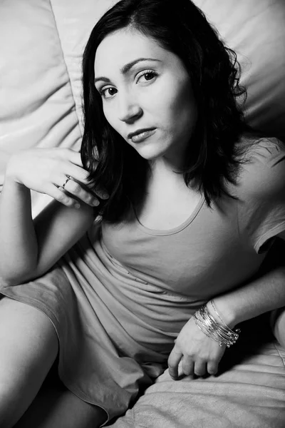 Krásná žena relaxuje na bílé pohovce — Stock fotografie