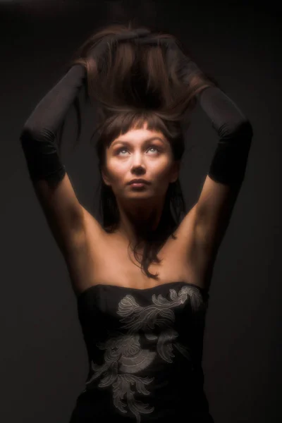 Портрет женщины с черными волосами на темном фоне — стоковое фото