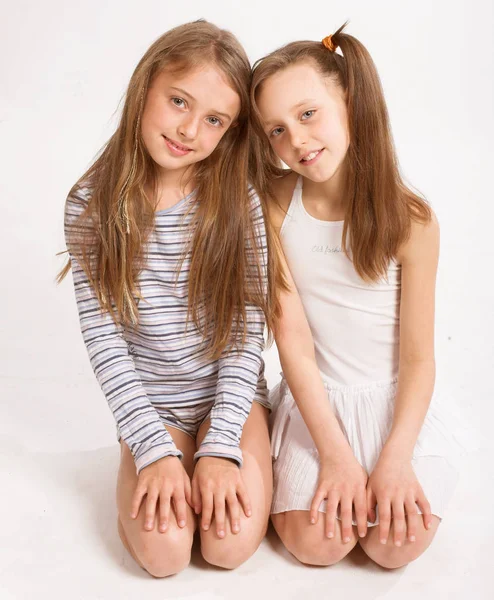 Дві маленькі дівчата на білому тлі — стокове фото