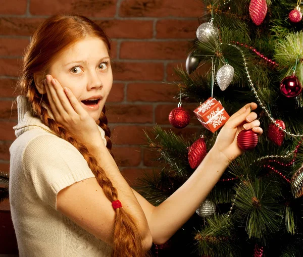 Chica decorar el árbol de Navidad en el interior de una casa — Foto de Stock