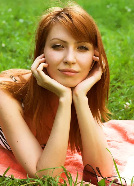 Smiling woman relaxes on the grass — Stock Photo, Image