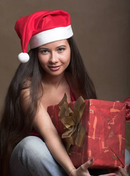 Hermosa mujer joven con sombrero de Santa Claus con presente — Foto de Stock