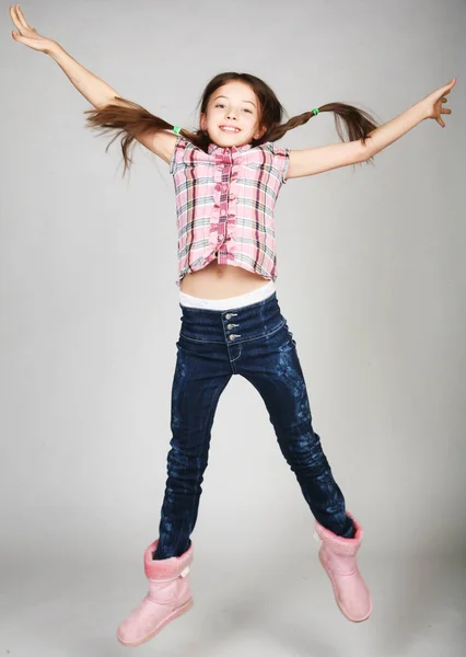 Девушка прыгает на сером фоне — стоковое фото