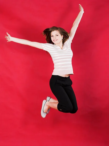 Girl jumping of joy over red — Stock Photo, Image