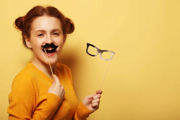 Estilo de vida e conceito de pessoas: Menina feliz vestindo bigodes falsos — Fotografia de Stock