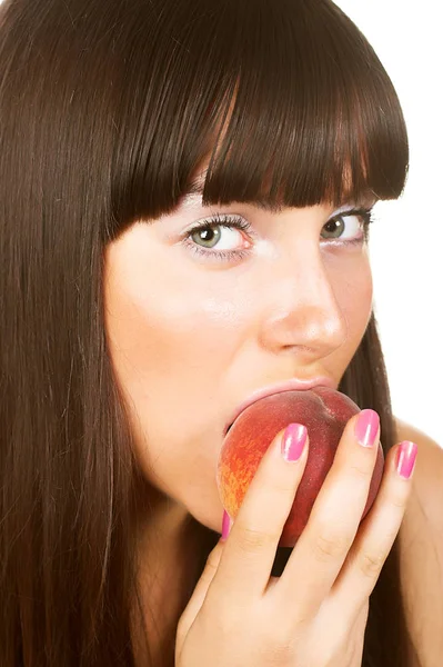 Hermosa mujer joven comiendo un melocotón. — Foto de Stock