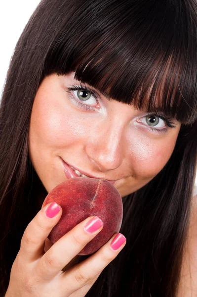 Hermosa mujer joven comiendo un melocotón. — Foto de Stock