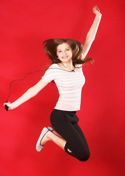 Дівчина стрибає з радості над червоним — стокове фото