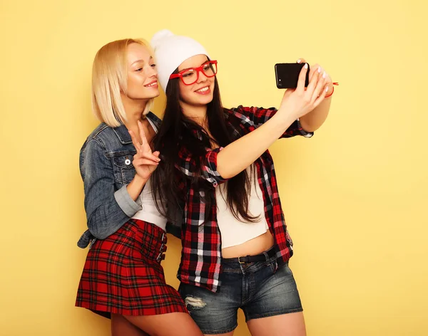 Dívky s smartphone na žlutém pozadí. Happy vlastní — Stock fotografie
