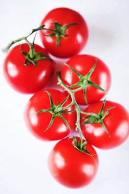 beyaz zemin üzerine yeşil dal üzerinde kırmızı domates