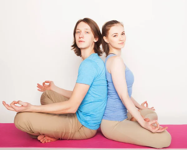 Lifestyle, sport  and people concept: Young couple in yoga pose — Stock Photo, Image